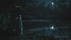 Nachts erhellt der blasse Mond einen überwucherten See. Eine geisterhafte Erscheinung steht am Ufer und blickt auf den See hinaus. Die Atmosphäre ist düster und unheimlich.